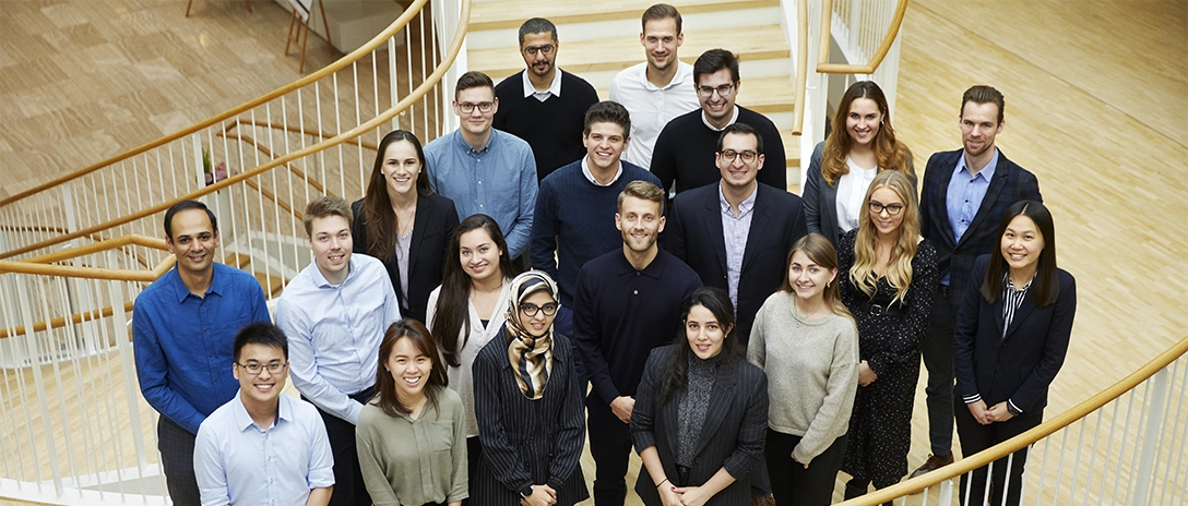 A large diverse group of Hempel colleagues standing together on a staircase, smiling at the camera.