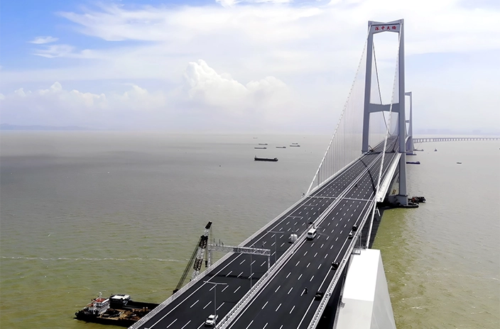 View of the Shenzhen-Zhongshan Bridge stretching across the water, with vehicles driving along its multiple lanes.